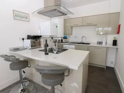 a kitchen with a counter with two wine glasses at Harbourside Apartment - 1 Bedroom - Sleeps 2 in Whitehaven