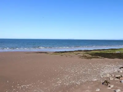 an empty beach with the ocean in the background at Harbourside Apartment - 1 Bedroom - Sleeps 2 in Whitehaven