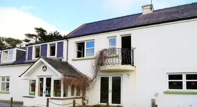 a white house with a black roof at Portling View in Dalbeattie