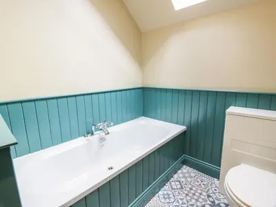 a bathroom with a tub and a toilet at Auchenvhin - Rockcliffe in Dalbeattie