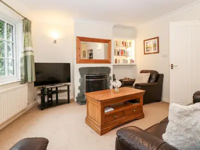 a living room with a couch and a fireplace at Holly Cottage in Ambleside