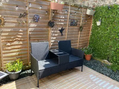two chairs sitting on a patio in front of a fence at The Snug in Cockermouth