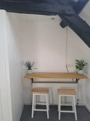a table and two stools in a room at The Snug in Cockermouth
