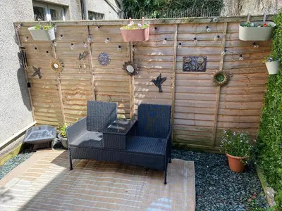 a patio with two chairs and a fence at The Snug in Cockermouth