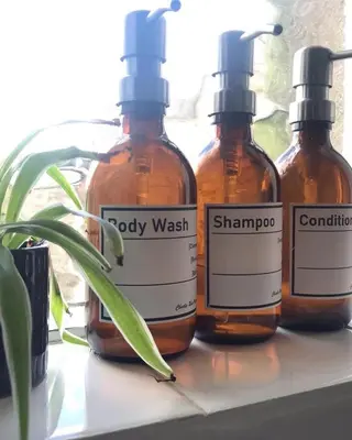 three bottles of soap sitting on a window sill at Roses Cottage cosy countryside home with open fire and mountain views near Scafell in Santon Bridge