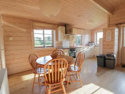 a kitchen with a dining room table and chairs at Lapwing Lodge in Dumfries