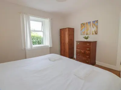 a bedroom with a large white bed and a window at West Lodge in Dumfries