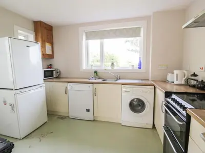 a kitchen with a white refrigerator and a dishwasher at West Lodge in Dumfries