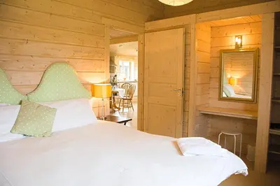 a bedroom with a white bed and a mirror at Skylark Lodge in Dumfries