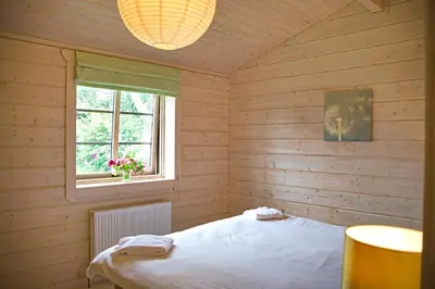 a bedroom with a bed in a wooden room at Skylark Lodge in Dumfries