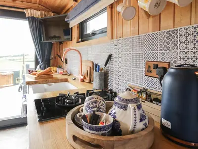 a kitchen with a stove and a counter top with pots at Greenacres Carriage in Maybole