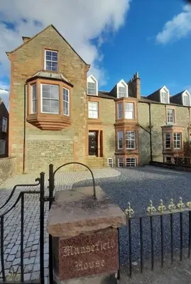 a house with a sign in front of a fence at Kirkcudbright Holiday Apartments - Apartment F in Kirkcudbright