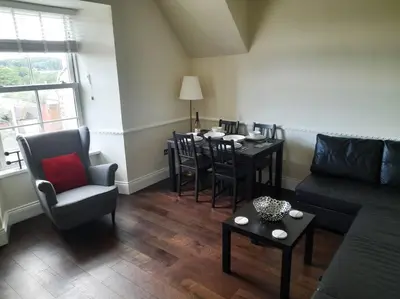 a living room with a couch and a table and chairs at Kirkcudbright Holiday Apartments - Apartment F in Kirkcudbright
