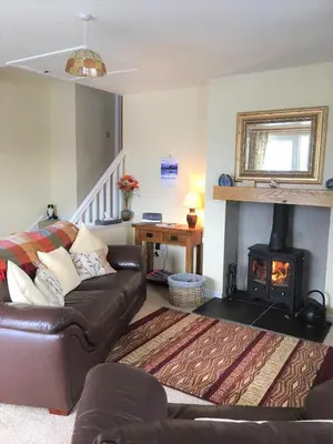 a living room with a couch and a fireplace at Laghead Steading Cottage in Gatehouse of Fleet