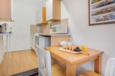 a small kitchen with a wooden table with fruit on it at cottage 7 old farmhouse mews in Keswick