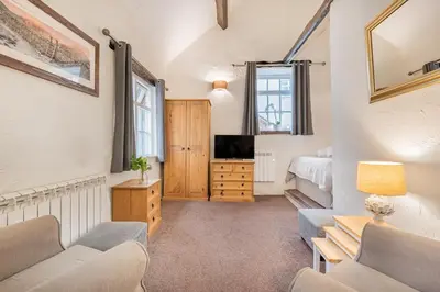 a living room with a couch and a tv at cottage 7 old farmhouse mews in Keswick