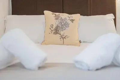 a bed with white sheets and a pillow on it at cottage 7 old farmhouse mews in Keswick