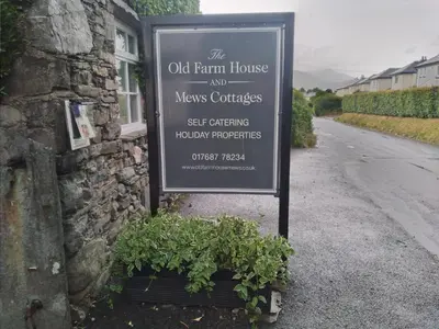 a sign on the side of a house with plants at cottage 7 old farmhouse mews in Keswick