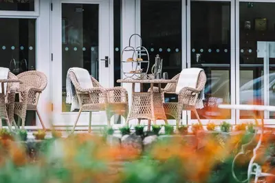 a group of wicker chairs and a table on a patio at Bridge House Hotel & Silver Howe View Cottage in Grasmere
