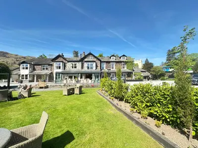 a large house with a green lawn in front of it at Bridge House Hotel & Silver Howe View Cottage in Grasmere