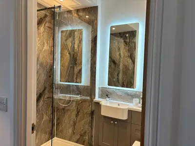 a bathroom with a shower and a sink and two mirrors at Braithwaite House Rooms in Braithwaite