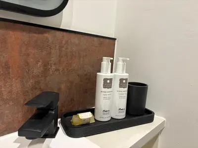 a bathroom with two bottles of soap and cheese at Braithwaite House Rooms in Braithwaite