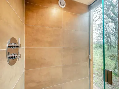 a shower in a bathroom with a glass door at The Treehouse Caerlaverock - Uk45028 in Carsethorn