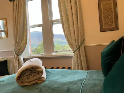 a bedroom with a bed with a towel on it at Maple Bank Country Guest House in Keswick