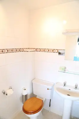 a white bathroom with a toilet and a sink at Keswick Park Hotel in Keswick