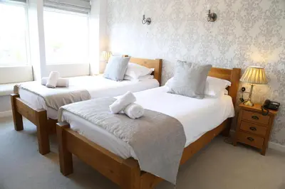 a bedroom with two beds with towels on them at Keswick Park Hotel in Keswick