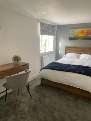 a bedroom with a bed and a desk and a chair at White House in Carlisle