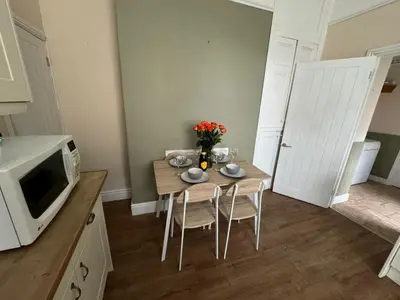 a kitchen with a table with chairs and a microwave at Ennerdale Edge - 4 Bedrooms - Sleeps 8 in Cleator Moor