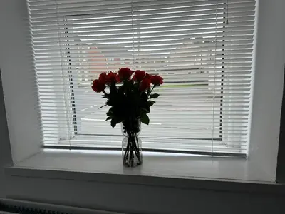 a vase of red roses sitting in a window at Ennerdale Edge - 4 Bedrooms - Sleeps 8 in Cleator Moor