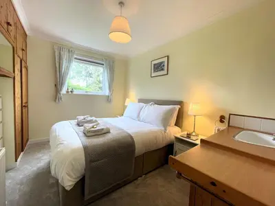 a bedroom with a large bed and a sink at Traditional Scottish Cottage in Beautiful Location - Pass the Keys in Rockcliffe