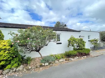 a white house with a tree in front of it at Traditional Scottish Cottage in Beautiful Location - Pass the Keys in Rockcliffe