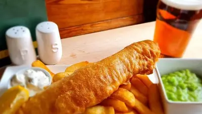 a plate of food with french fries and a roll at The Plough Inn in Carlisle