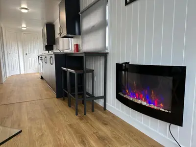 a living room with a fireplace in the wall at Lagavulin 3 in Portpatrick