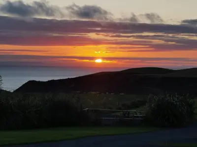 a sunset with the sun setting over the ocean at Lagavulin 3 in Portpatrick