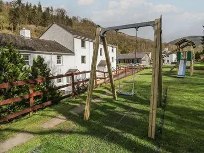 a swing set in a yard next to a fence at Canadian Cabin 37 in Keswick