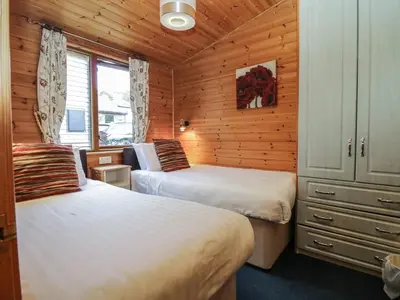 a bedroom with two beds in a wooden cabin at Elm Lodge in Keswick