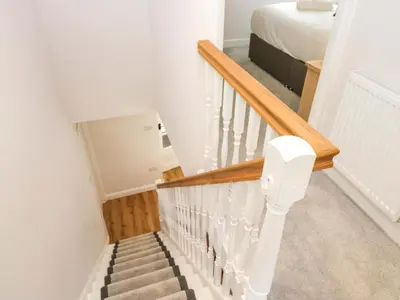 a staircase in a bedroom with a bed at Riverside Cottage No 4 in Keswick