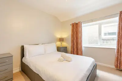 a bedroom with a bed and a window at Hummingbird House in Cockermouth