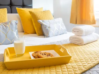 a box of food on a bed with a glass of milk at Mountain View Beautiful Large House By Cockermouth in Cockermouth