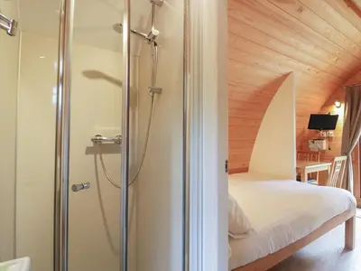 a bathroom with a shower and a bed in a room at Pod No 28 in Keswick