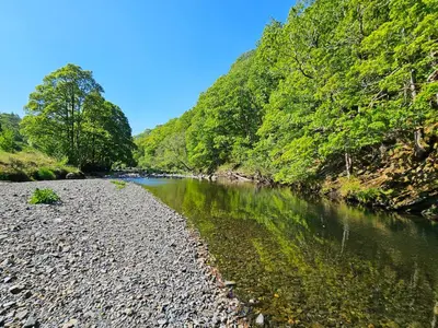 a river with rocks and trees on the side of it at Pod No 28 in Keswick