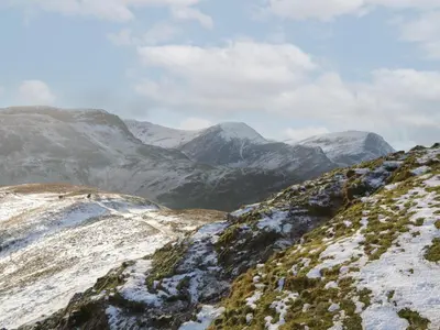 a snowy mountain with snow covered mountains in the background at Pod No 5 in Keswick