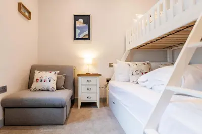 a bedroom with a bunk bed and a chair at Briery House in Keswick