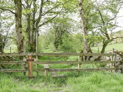a wooden fence in a field with trees at Briery House in Keswick