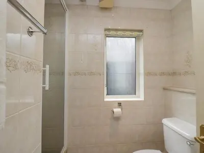 a bathroom with a shower and a toilet and a window at Chestnut Timber Lodge in Keswick