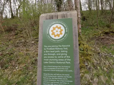 a sign for a hiking trail in the woods at Chestnut Timber Lodge in Keswick